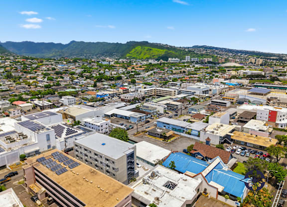 A cityscape with buildings and solar panels on the roofs.