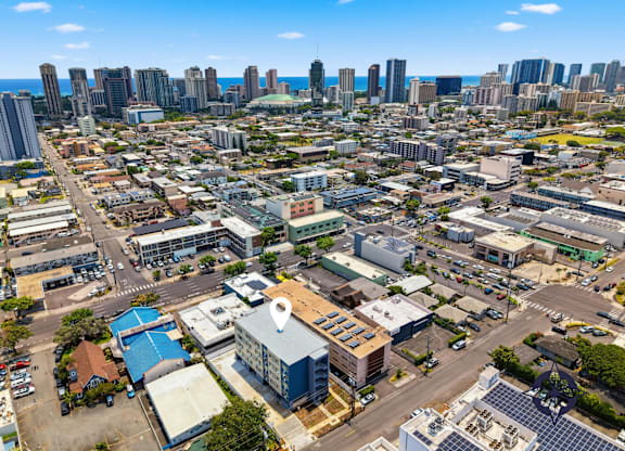 A cityscape with a mix of residential and commercial buildings under a clear sky.