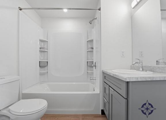 A white bathroom with a toilet, sink, and bathtub.
