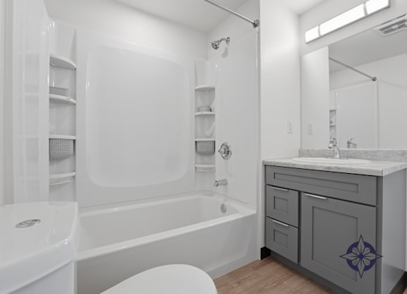 A white bathroom with a white toilet, a white sink, and a white bathtub.