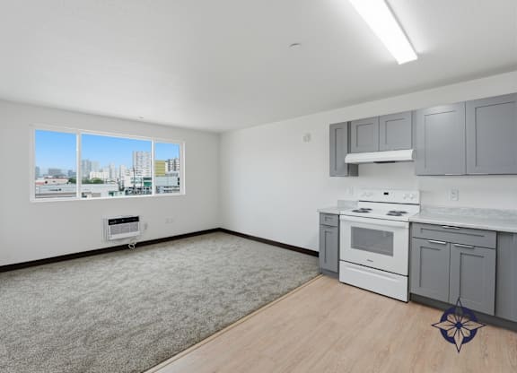 A kitchen with white appliances and grey cabinets.