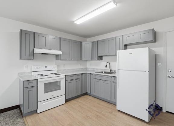 A kitchen with white appliances and grey cabinets.