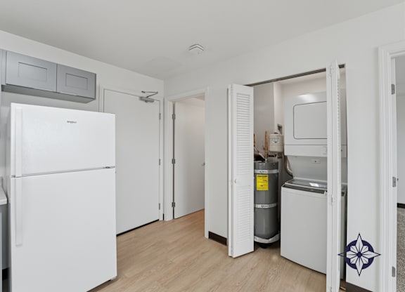 A white refrigerator is in a kitchen with a white door.