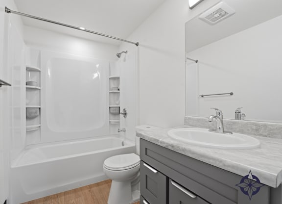 A white bathroom with a toilet, sink, and bathtub.