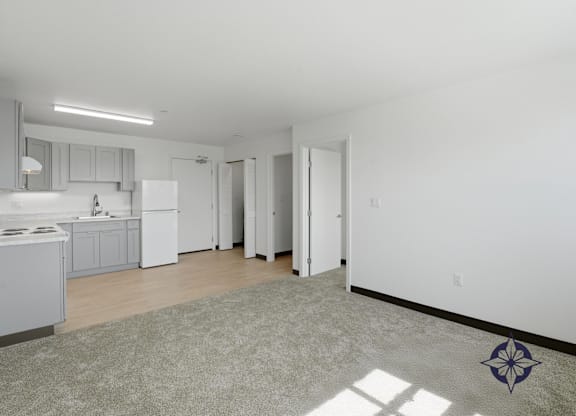 A kitchen with white appliances and a rug on the floor.