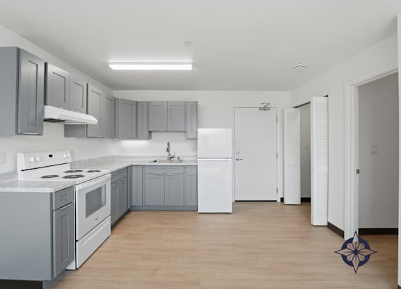 A kitchen with white appliances and grey cabinets.