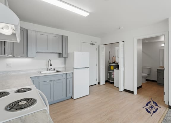 A kitchen with a white fridge and a stove top.