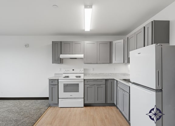 A kitchen with white appliances and grey cabinets.