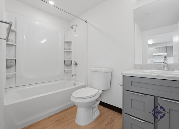 A white toilet sits in a bathroom next to a bathtub and sink.