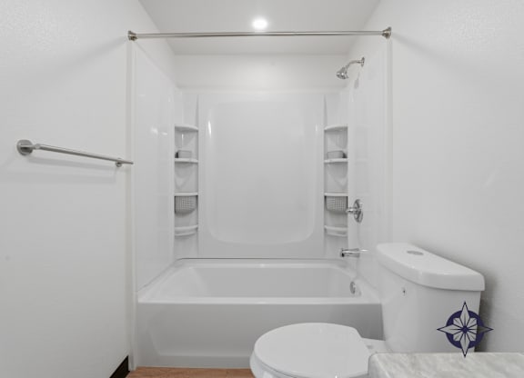 A white bathroom with a toilet, sink, and shower.
