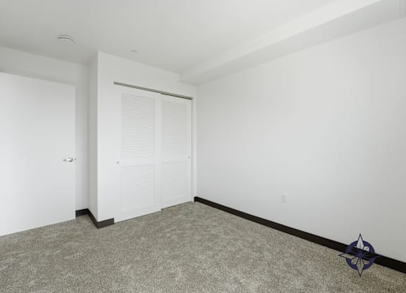 A room with a carpeted floor and a white door.