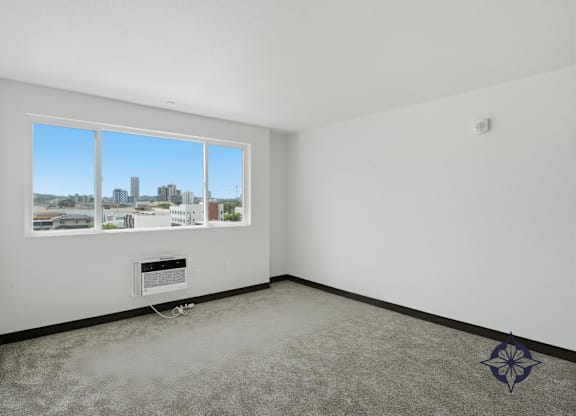 A room with a large window overlooking a cityscape.