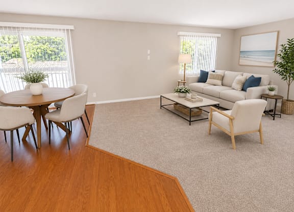 A living room with a white couch, a coffee table, and a dining table with chairs.