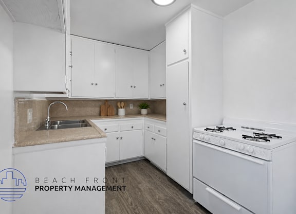 A kitchen with white cabinets and a stove top oven.