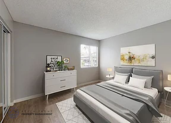 A well-lit bedroom with a large bed and a nightstand with a lamp.