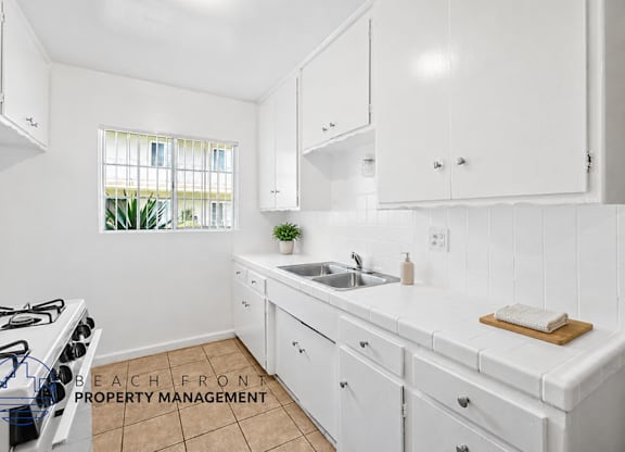 A kitchen with white cabinets and a tiled backsplash.