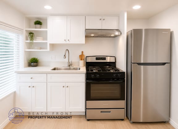 A modern kitchen with a stainless steel refrigerator and stove.