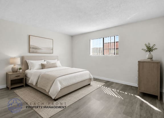 A well-lit bedroom with a large bed and a wooden nightstand.