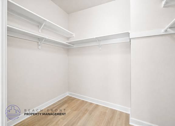 A white room with a wooden floor and white walls.