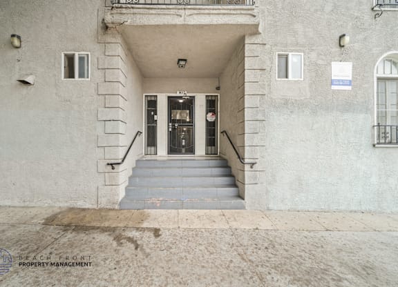 A building entrance with a sign for Beach Front Property Management.