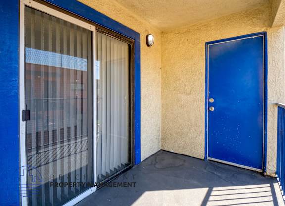A blue door is on the right side of a window with a screen.