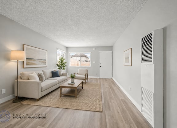 A living room with a couch, coffee table, and a window.