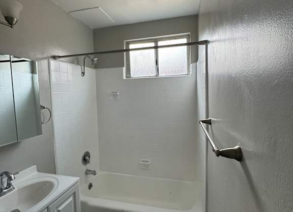 an empty bathroom with a shower and a sink