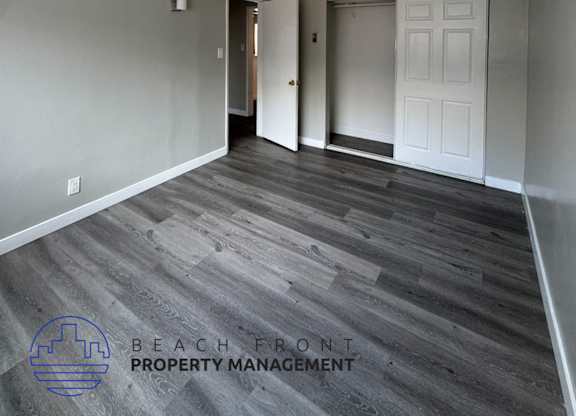 an empty living room with wood floors and a white door