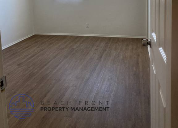 A room with a ceiling fan and wooden flooring.