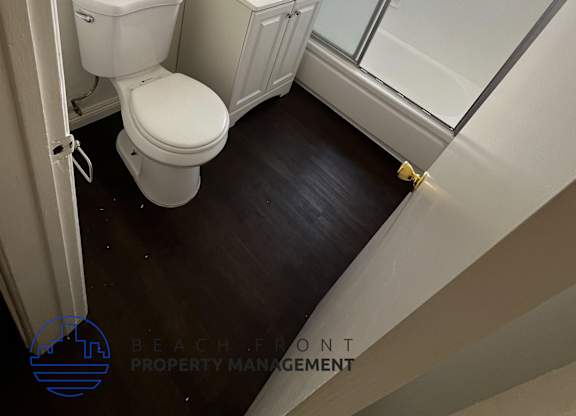 A white toilet and sink in a small bathroom.