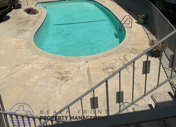 A pool surrounded by a fence and a sign that says