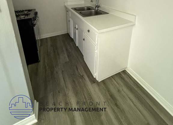 A small kitchen with white cabinets and a sink.