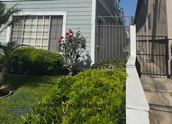 A blue house with a white fence and a gate.