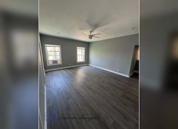 A room with wooden flooring and a ceiling fan.