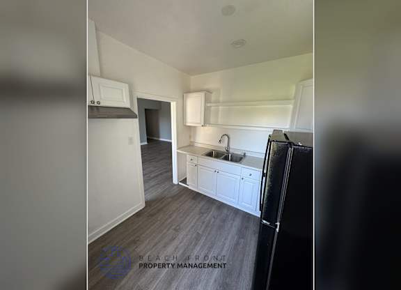 A kitchen with a sink, stove, and cabinets.