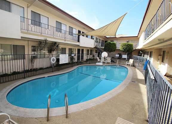 A small pool in a courtyard surrounded by buildings.