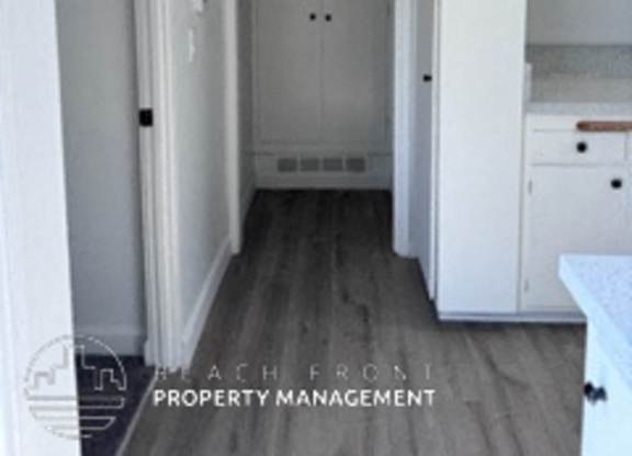 A hallway with a door at the end and a logo for Beach Road Property Management.