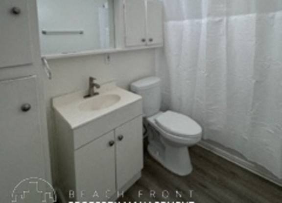 A bathroom with a toilet, sink, and shower curtain.