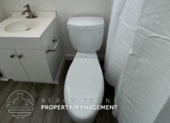 A white toilet sits next to a sink in a bathroom.