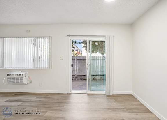 A room with a sliding glass door leading to a balcony.