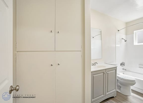 A white bathroom with a toilet, sink, and bathtub.