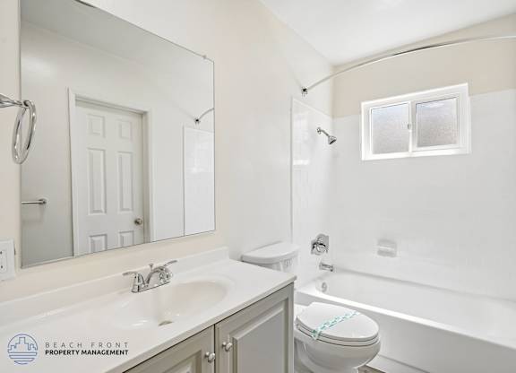 A white bathroom with a sink, toilet, and bathtub.