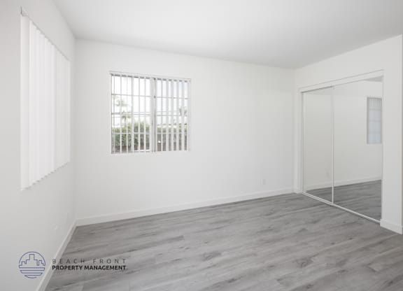 A room with a window and a door is empty and waiting to be furnished.