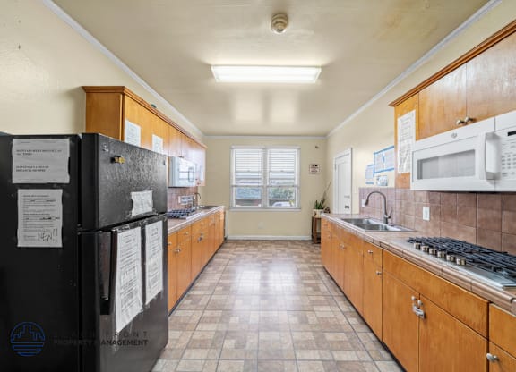A kitchen with black appliances and wooden cabinets.