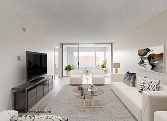 A living room with a white couch, a television, and a coffee table.