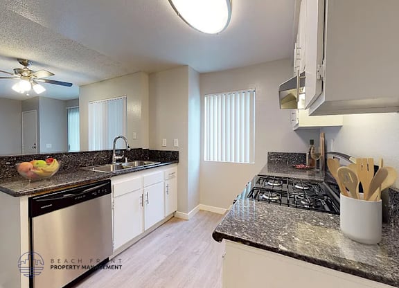 A kitchen with a black stove top oven and white cabinets.