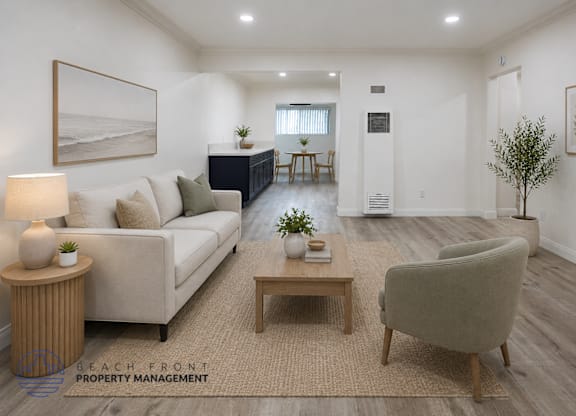 A living room with a white couch, a wooden coffee table, and a lamp on a side table.