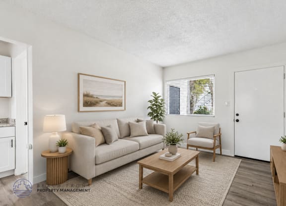 A living room with a couch, chair, and table.