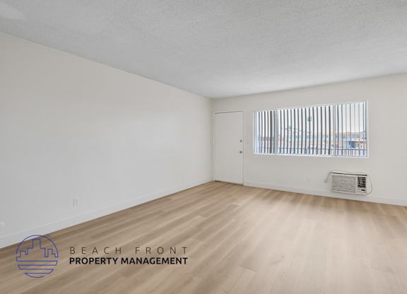A room with a window and a logo for Beach Front Property Management.