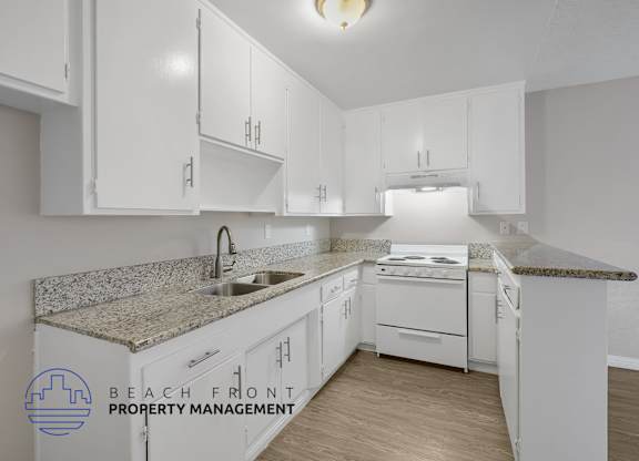 A kitchen with white cabinets and a granite countertop.